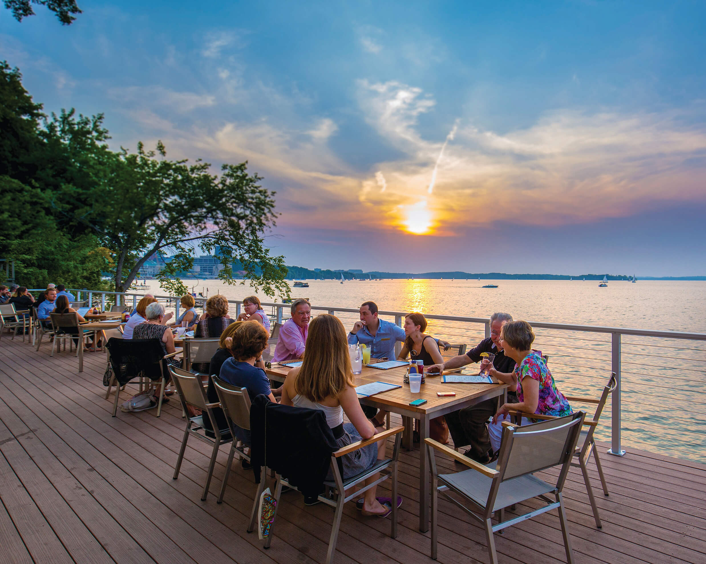 Patrons enjoying the boathouse at sunset.